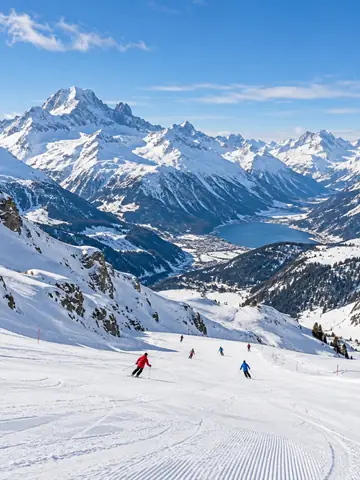 Snowy alpine mountains with distant skiers